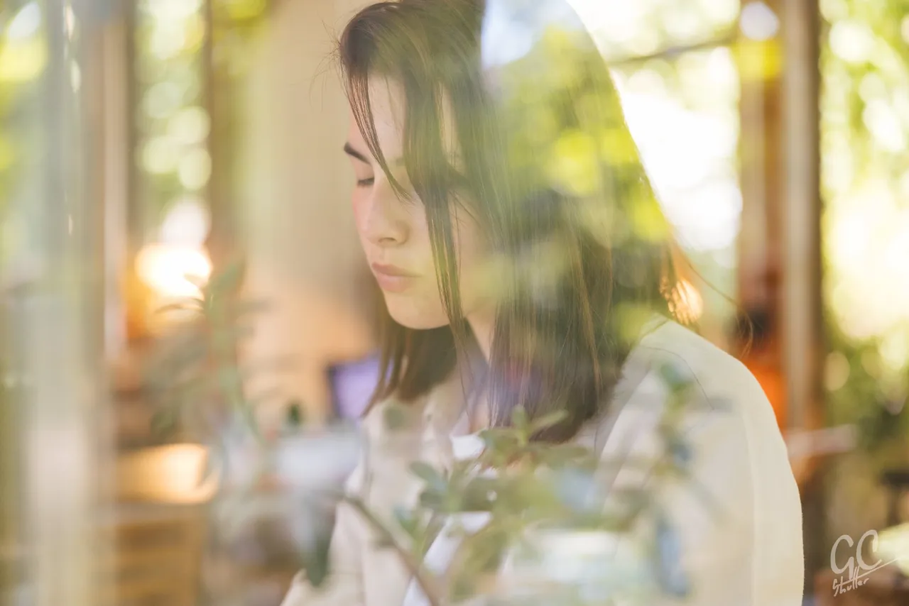 Woman by a sunlit window, photographed by GCShutter