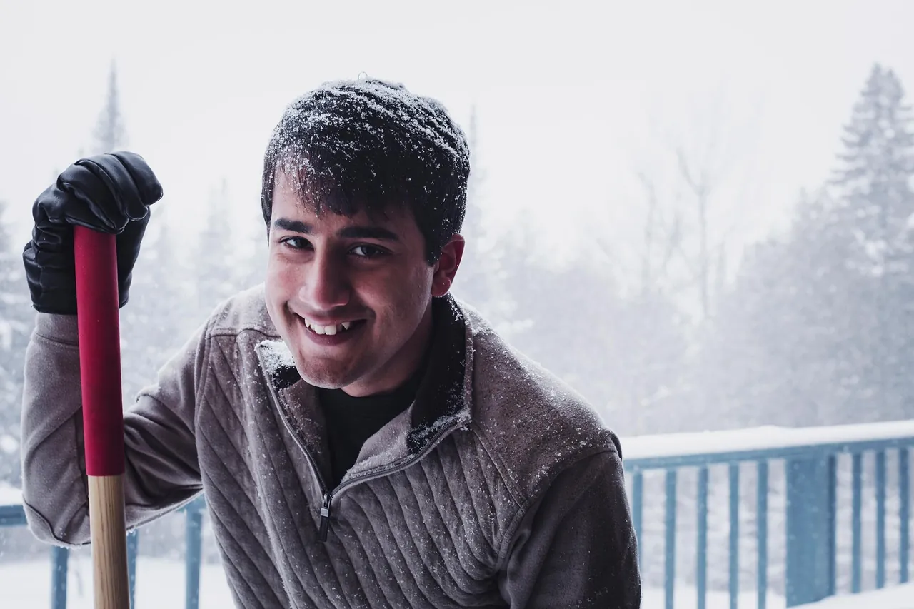 Smiling man with a shovel in the snow, photographed by GCShutter