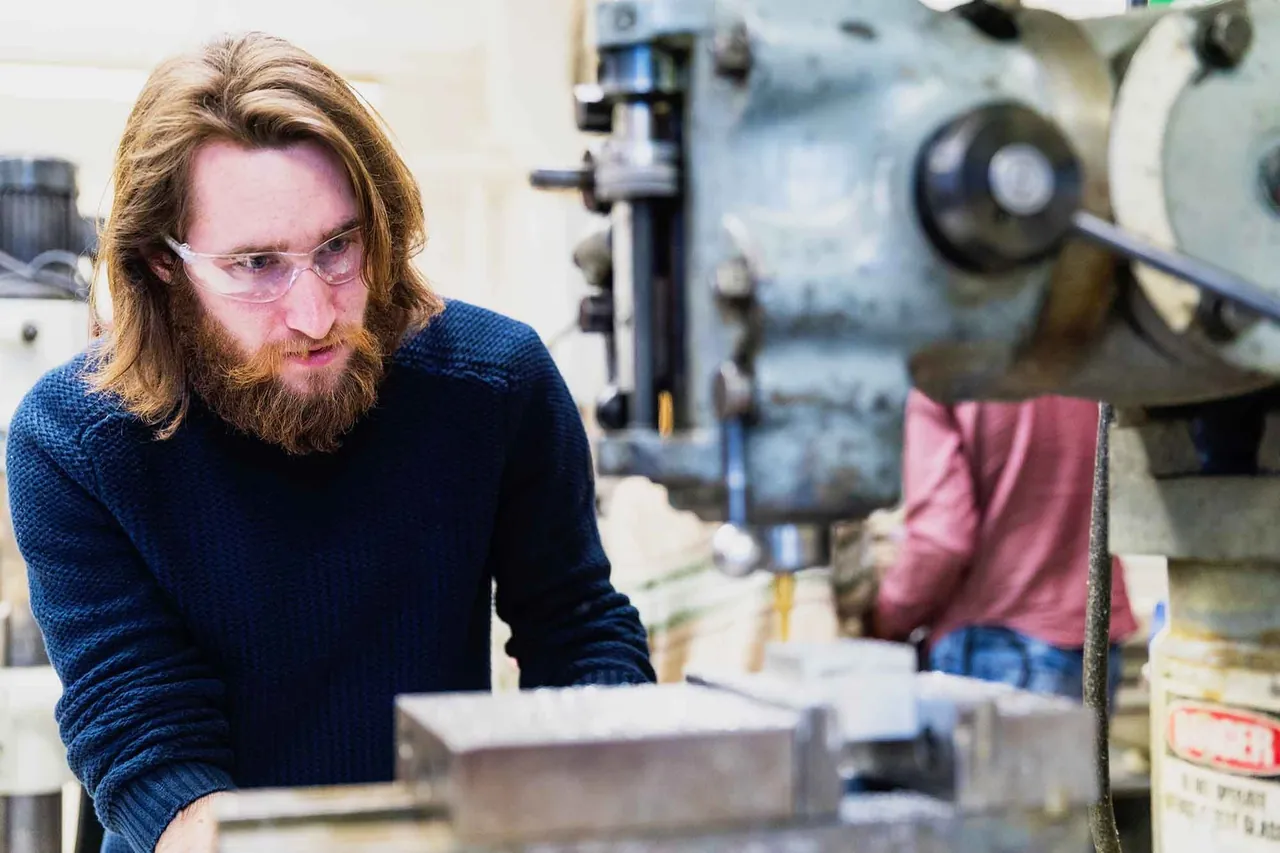 Young man at work in a machine workshop, photographed by GCShutter